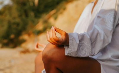 Close-up of a person's hands in a meditative mudra.